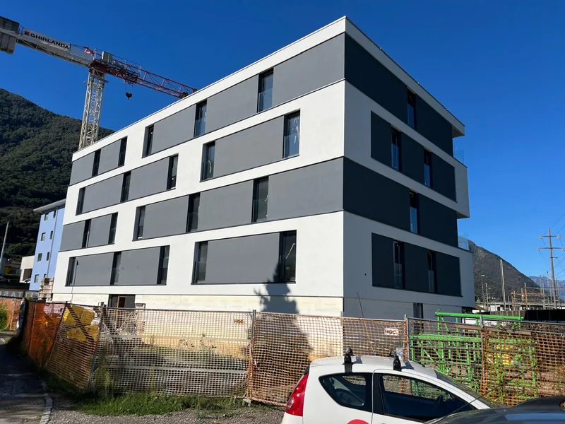 Edificio residenziale con facciata bianca e fasce antracite